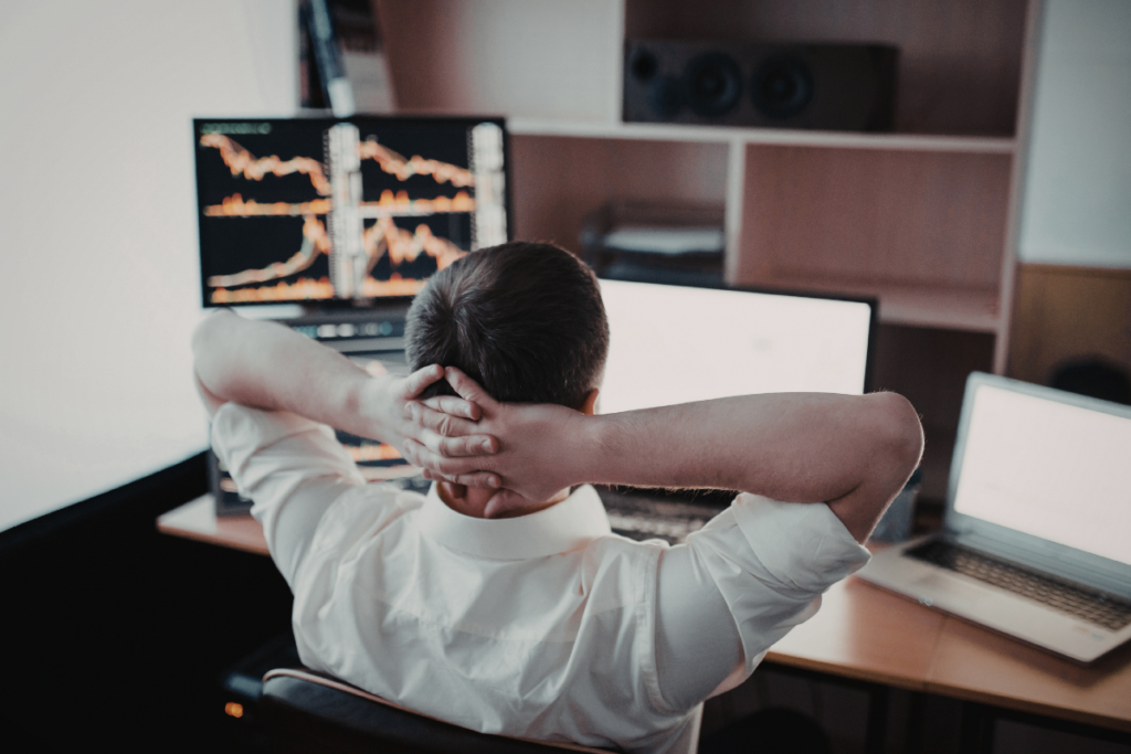 Business owner overwhelmed by complex manual data systems on multiple monitors, representing operational friction and the need for scalable AI architecture.